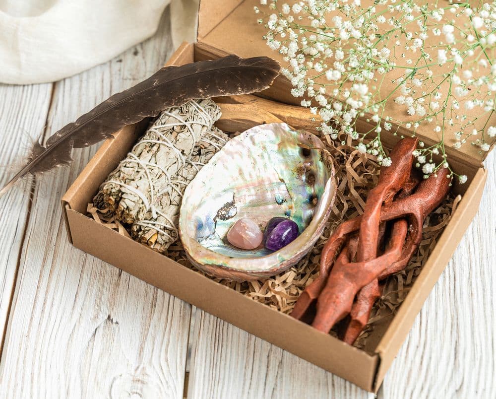 Deluxe smudging kit with white sage, abalone shell, amethyst and rose quartz crystals used for energy cleansing and purification rituals — perfect for cleansing amethyst stones and restoring positive energy.